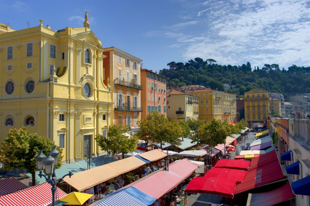 Vista desde arriba del mercado de Cours Saleya en Niza con puestos cubiertos y edificios antiguos