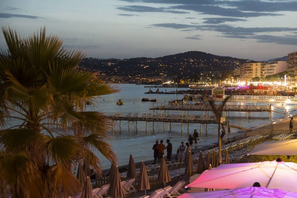 Juan les Pins de noche con bares iluminados en primer plano y mar detrás