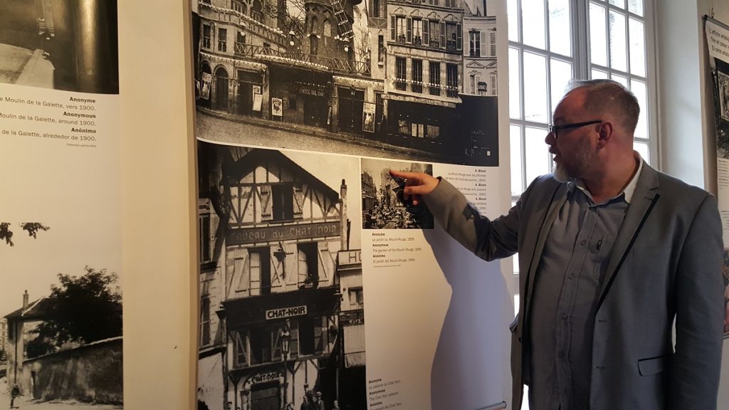 Galería Amboise del Museo Toulouse-Lautrec con un hombre presentando fotografías 