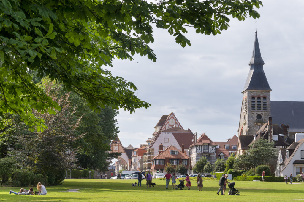 Le touquet con jardines e iglesia y pueblo verde con gente delante