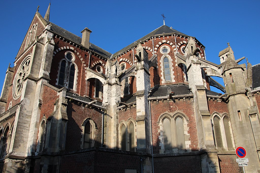 Una vista mirando hacia el costado de la iglesia de Saint Pierre en Calais que muestra una iglesia de ladrillo rojo y una bahía redonda