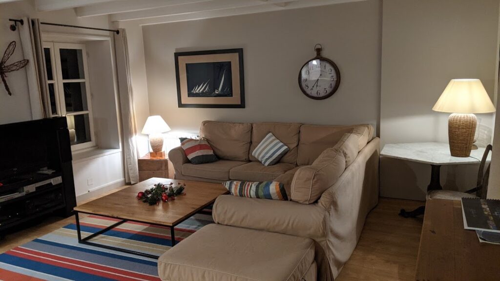Interior de la sala de estar en una casa rural en Wissant, en el norte de Francia, mostrando una lámpara, cómodos sofás, un gran reloj en la pared