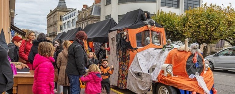 Un tren turístico en Limoges disfrazado con los colores de Halloween con gente y niños mirando