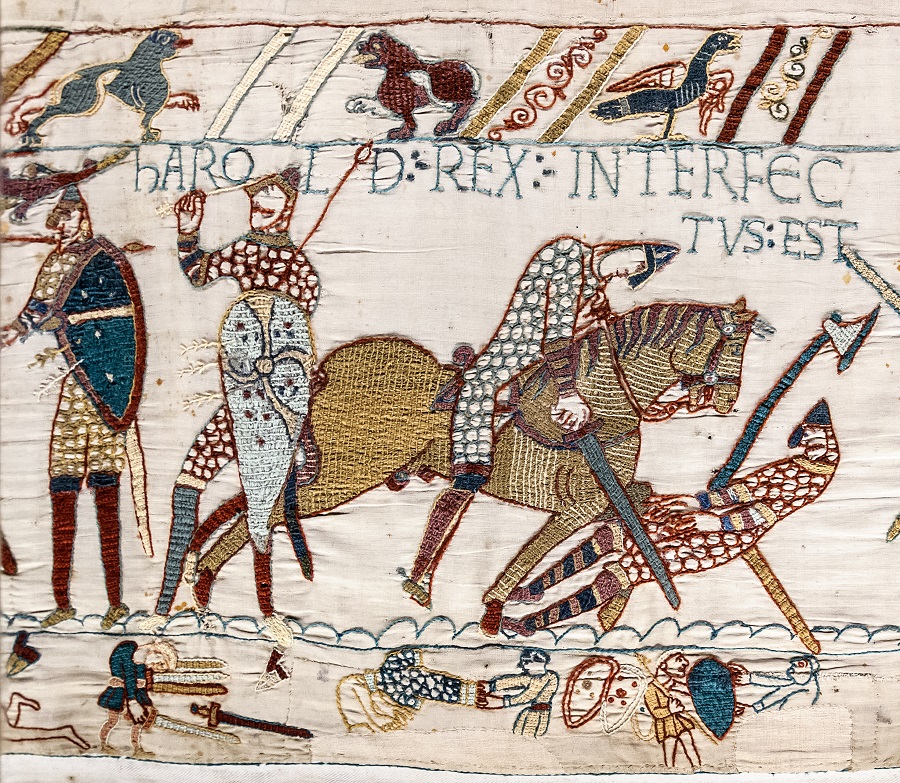 El tapiz de Bayeux de la muerte de Harold, un trineo tirado por un caballo, una espada en el cuerpo de un hombre en el suelo y Harold de pie a la izquierda con una flecha en el ojo.