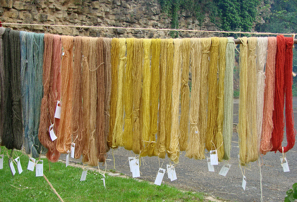 Pieles de lana colgadas para secarse en una feria medieval en Sedan en colores verde brillante a ocre