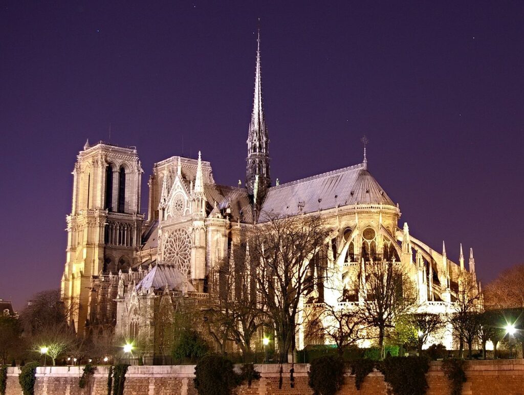 Notre-Dame de Paris de noche desde atrás mostrando todo el edificio iluminado antes del incendio de 2022