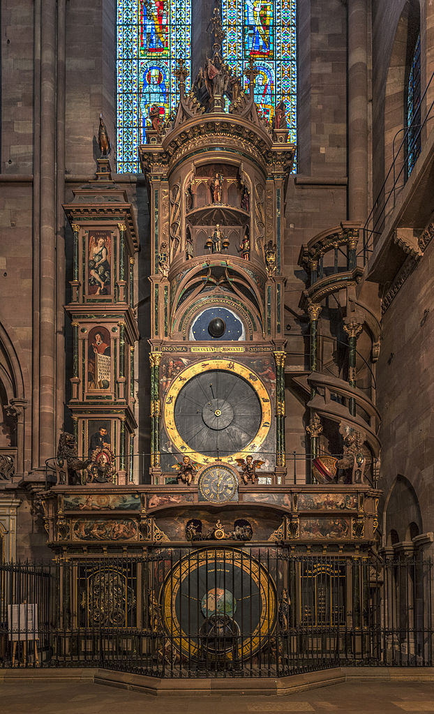 Reloj astronómico de la Catedral de Estrasburgo. La catedral de piedra roja tiene varios niveles con una campana elaborada en la parte inferior y tres niveles en la parte superior.