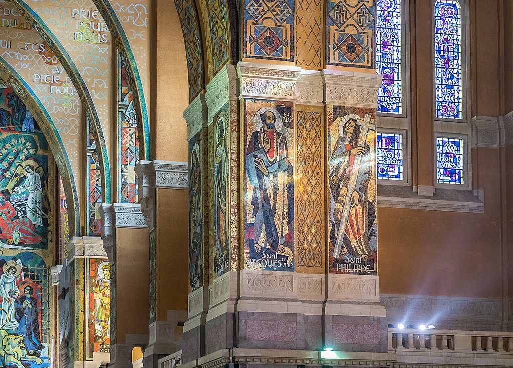 Interior de la basílica de Santa Teresa de Lisieux que muestra coloridos pilares de capital en un ángulo lateral