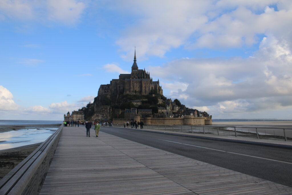 Vista desde el puente que cruza la bahía al Mont St Michel con gente caminando