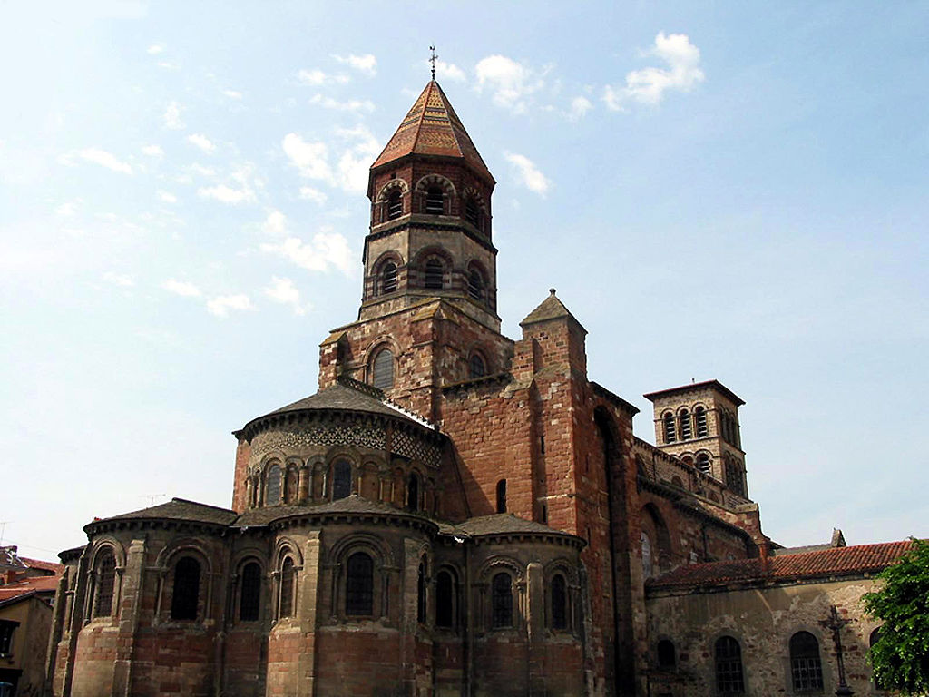 La basílica de piedra roja y negra de St. Julien en Brioude mirando hacia el yugo redondo detrás y la torre