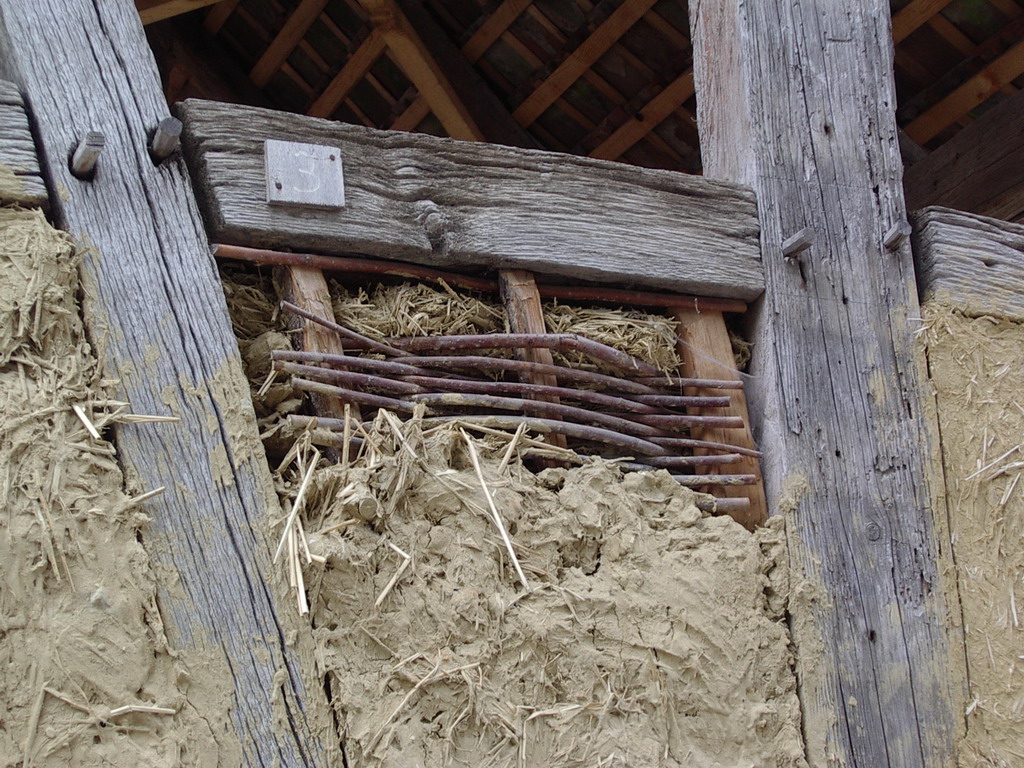 Armazón de media madera con relleno de mazorca de paja y arcilla húmeda en la estructura de palés