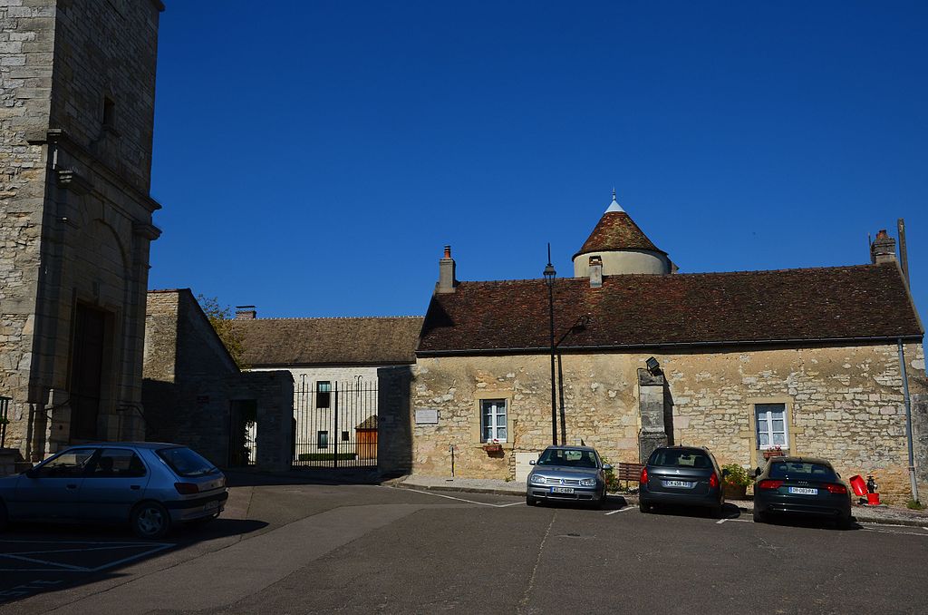 Frente del dominio de la Romanée_Conti que muestra las puertas a un patio, un edificio en la parte trasera y otros en un patio que incluye una torre cónica que se asoma por encima del techo. coches por delante