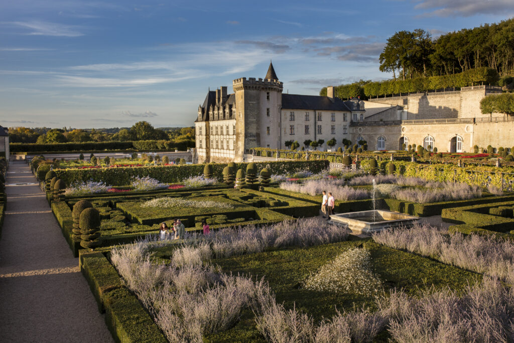 Chateau de Villandry al amanecer mostrando un castillo en una esquina y una pared a la derecha con jardines establecidos formalmente en el Valle del Loira