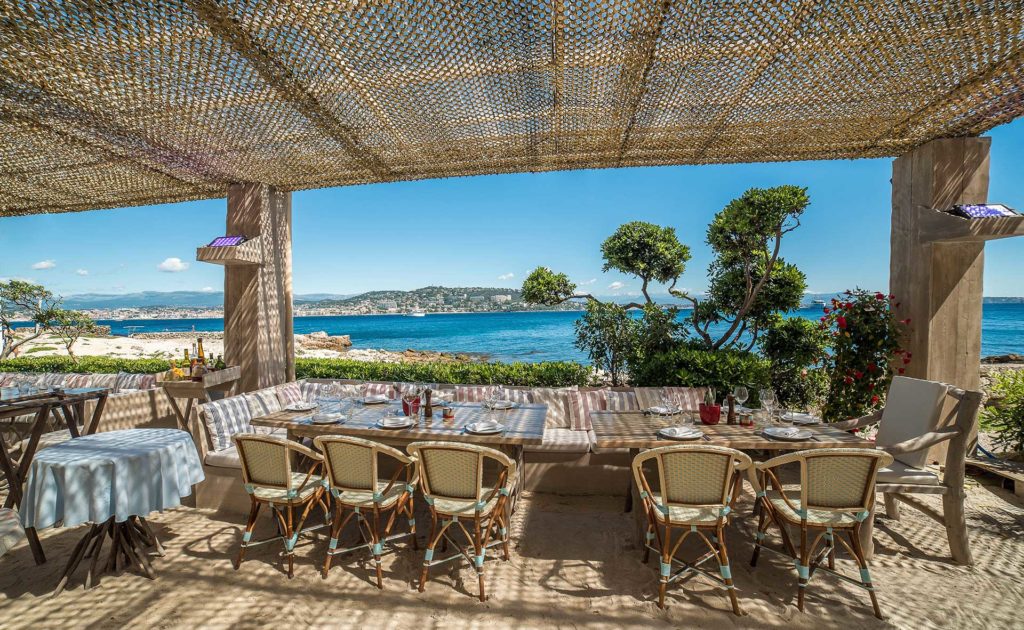 Una vista de la terraza en el restaurante la guerite ile ste marguerite con un dosel de bambú mirando al mar