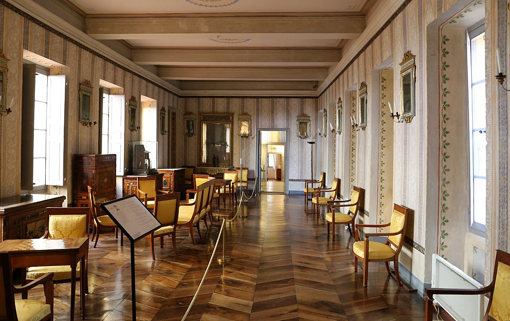 La casa de Napoleón en Ajaccio dentro de la larga galería con sillas reglamentadas en un lado y muebles en el otro. piso de madera pulida