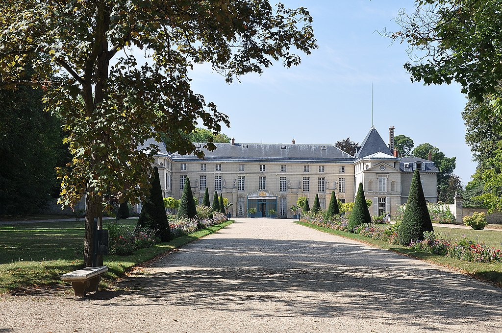 Chateau de Malmaison en el París de Napoleón que muestra un modesto edificio neoclásico de tres pisos en tres lados al final del camino de grava bordeado de árboles