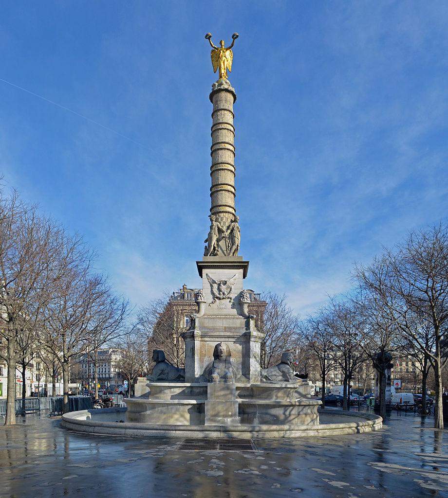 Fuente du Palmier en París que muestra un día lluvioso con una enorme fuente alta rodeada de estatuas de esfinges