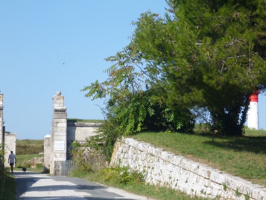 Un lado de la columna que marca la entrada a la ciudad principal de Ile d'Aix con un muro bajo de piedra y un parque a un lado