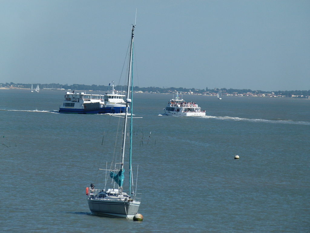 Vista al mar con velero al frente y travesía en ferry a Ile d'Aix atrás