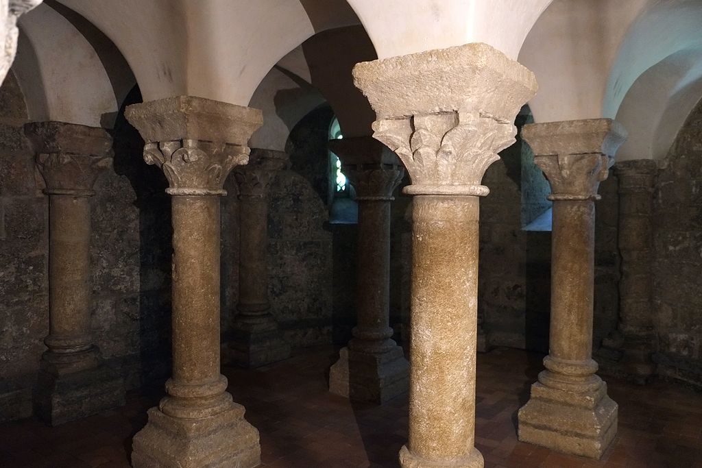 Cripta de San Martín Ile d'Aix con dos capiteles bien iluminados y tallados y fondo oscuro