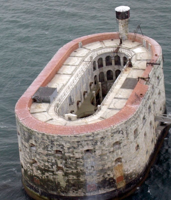 Vista aérea del mar Fort Boyard, una estructura de piedra ovalada con un patio frente a Ile d'Aix