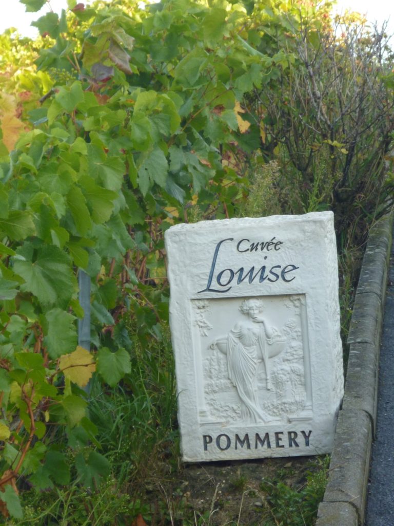 Una piedra llamada Cuvee Pommery y una imagen de una mujer tallada en una piedra en el viñedo de Pommery