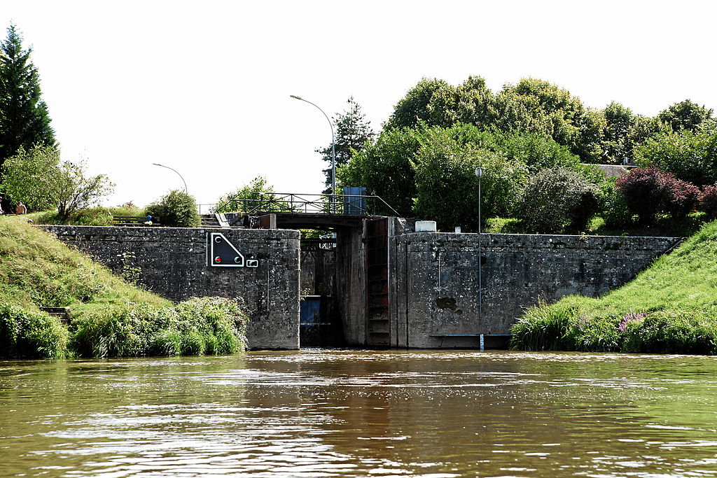 Canal Lateral a la Loire en Decize con relleno de canal frente a la imagen y bancos de verde a ambos lados que conducen a un pequeño bloqueo