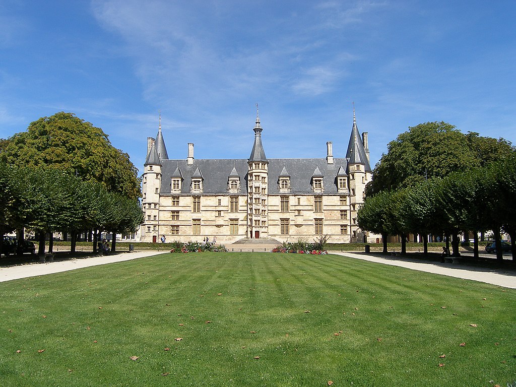 Vista lejana del Palacio de los Duques en Nevers, un edificio que parece un castillo con torres y cúpulas de cebolla, 3 pisos de piedra y techo de pizarra oscura