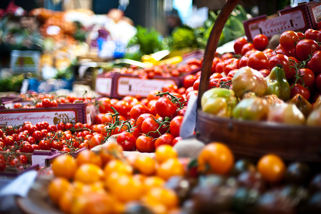 Un puesto recogido con tomates de todos los colores; rojo, naranja, negro