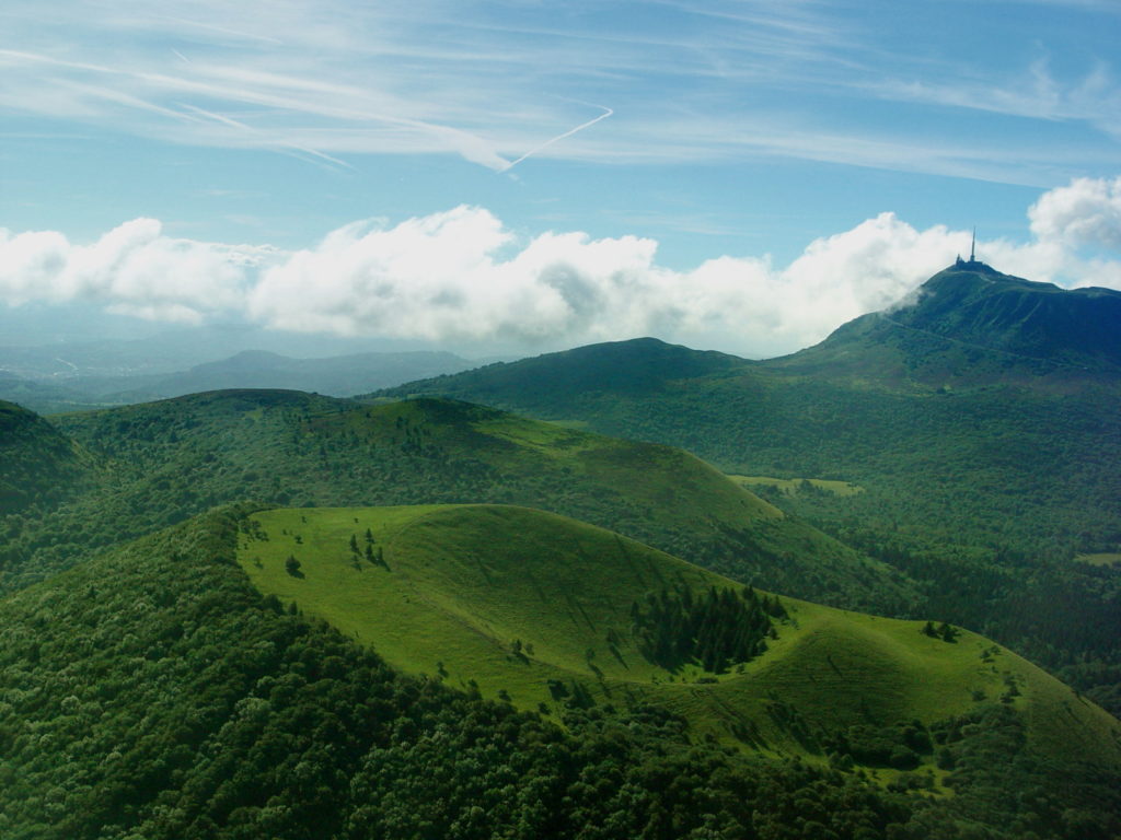 Una gran vista a lo largo de la gama verde de los cachorros con Puy de Dome en la distancia