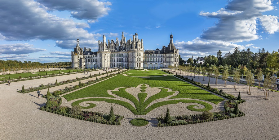 Valle del Loira Chateau de Chambord desde la distancia con jardines con macizos de flores con forma de flor de lis frente a un enorme edificio renacentista