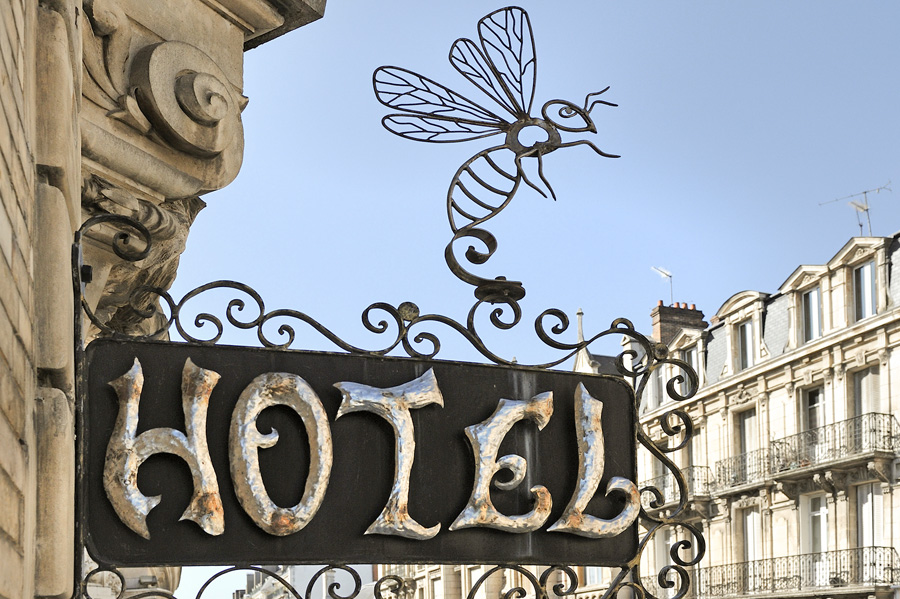 Regístrese en el Hotel de l'Abeille, regístrese al estilo antiguo 9El señor de los anillos) con el nombre del hotel y una abeja encima del letrero