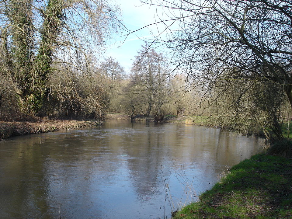 Río La Bresle con aguas lentas y árboles con follaje pequeño