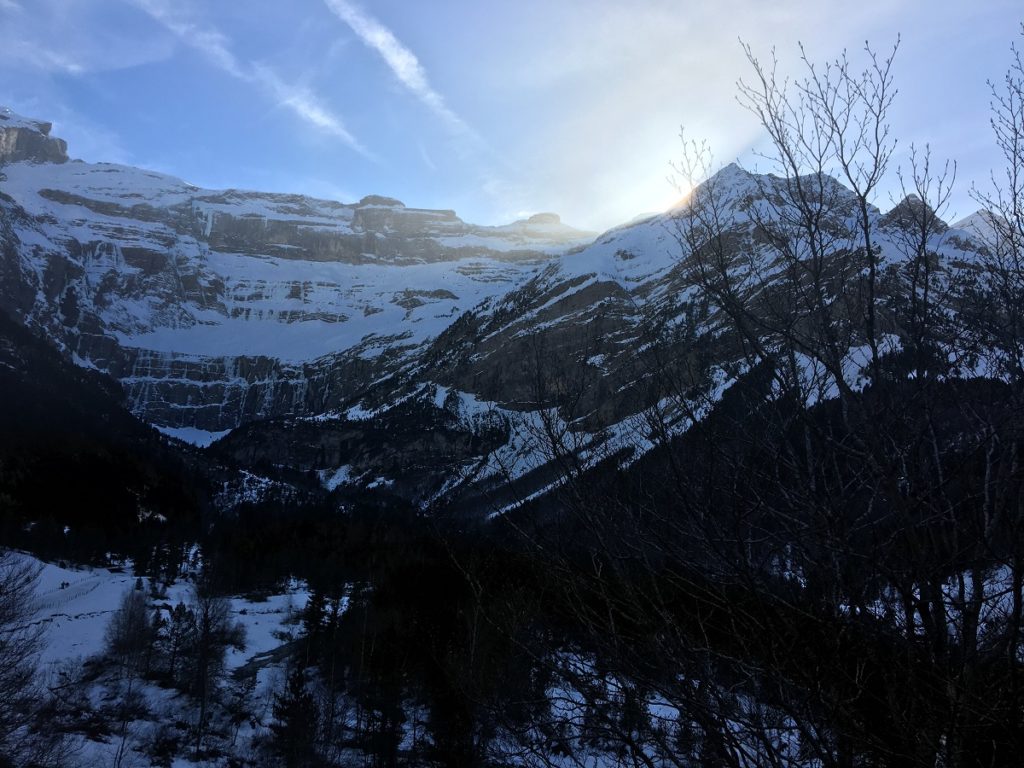 Puesta de sol sobre Cirque de Gavarnie con montañas cubiertas de nieve en la distancia