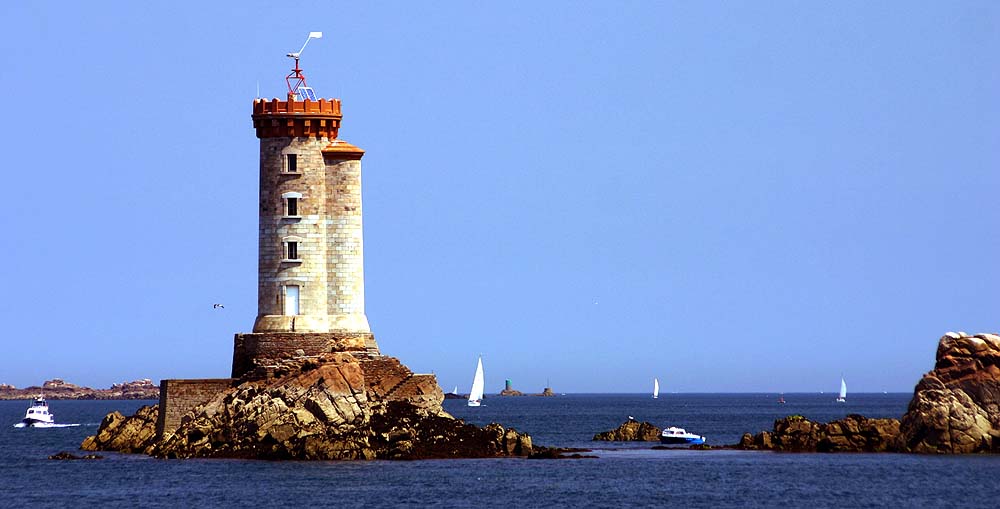 Ile de Brehat, la isla de Bretaña con dos faros sobre una gran roca a la izquierda, el mar a la derecha con yates navegando al fondo