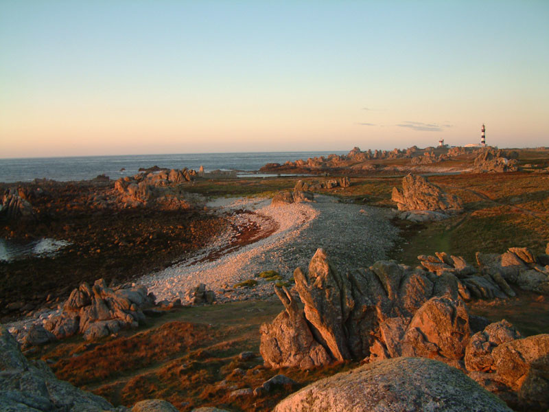 La Ponte de Pern Ouessant bretaña islas mostrando puesta de sol/amanecer sobre el mar a la izquierda, playa y rocas