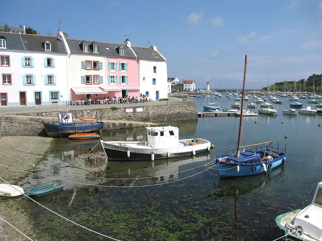 Puerto de Sauzon en la Belle-Ile de Bretaña con pequeñas embarcaciones en el puerto y muchas casas coloridas detrás