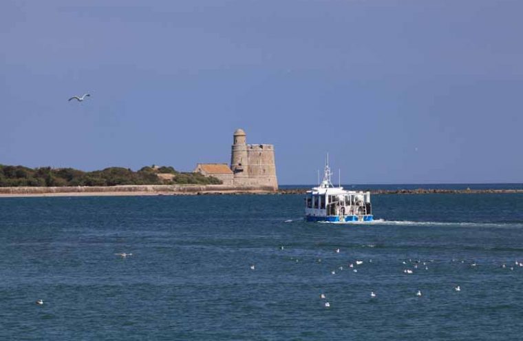 Una vista desde el mar con un barco anfibio en el agua acercándose al fuerte francés Tatihou