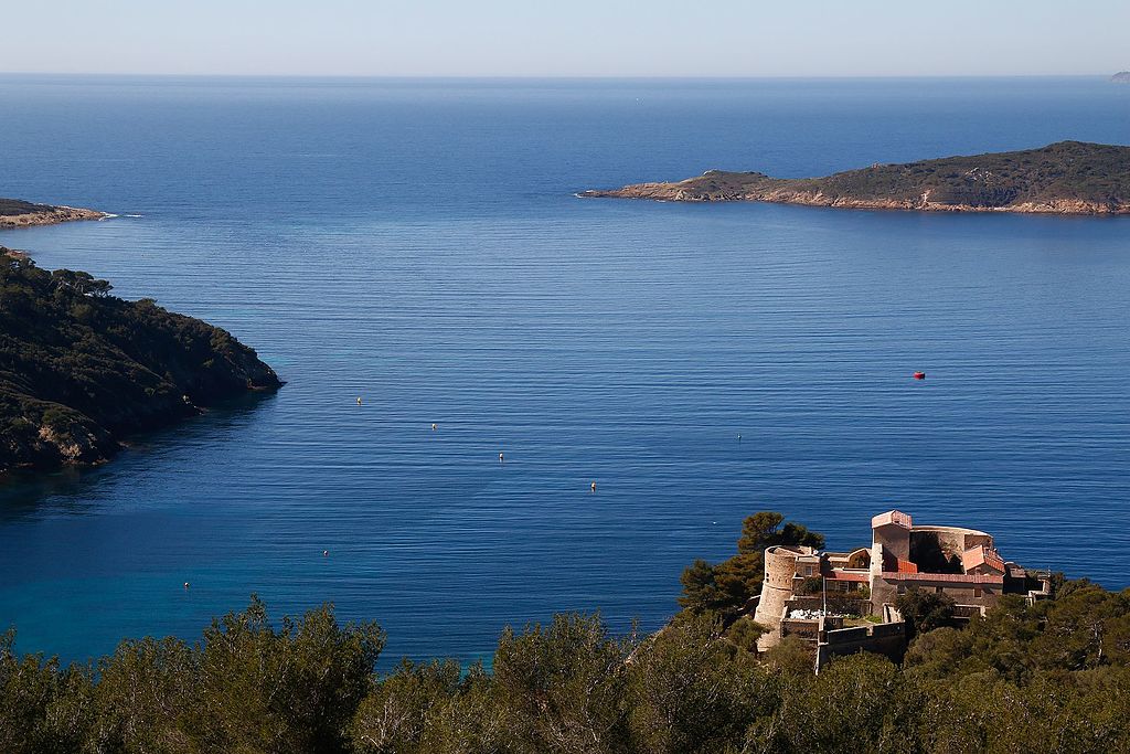 Port Cros Isles d'Hyeres Francia mediterránea con vistas a un pequeño fuerte antiguo en primer plano en la pieza verde, el promontorio a la izquierda y las islas en el fondo del mar azul