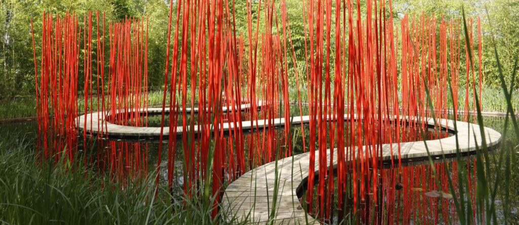 Jardines de Chaumont-sur-Loire con una instalación de Yo Kongjian que muestra hilos rojos colgando sobre grandes macetas de terracota