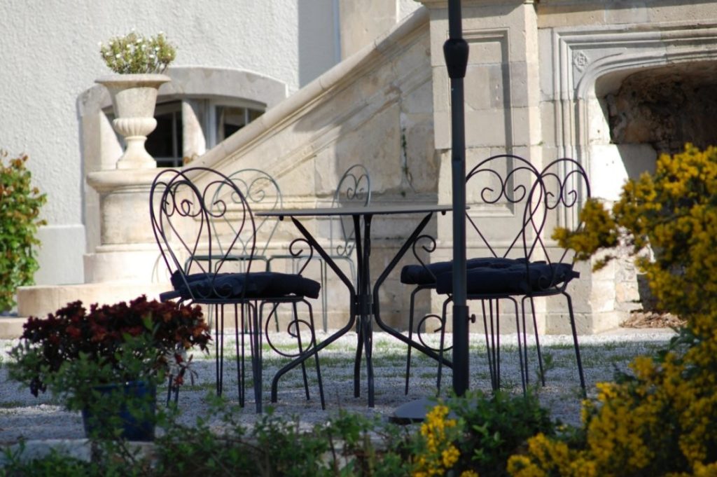 Sillas y escaleras en una terraza de piedra en Chateau de Quineville