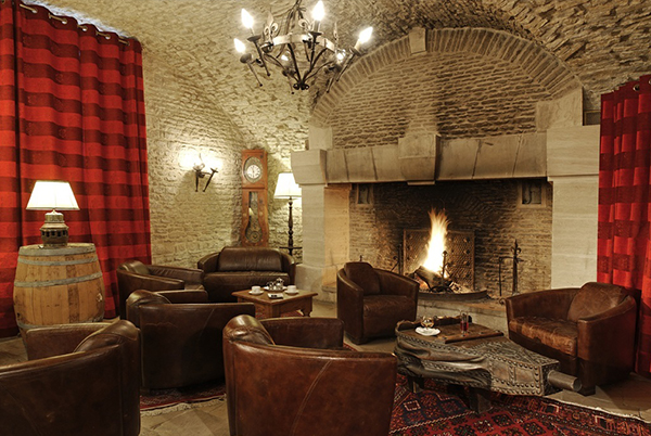 Paredes de piedra, candelabros, fuego medieval rugiente en la Ferme de la Rançonnière 