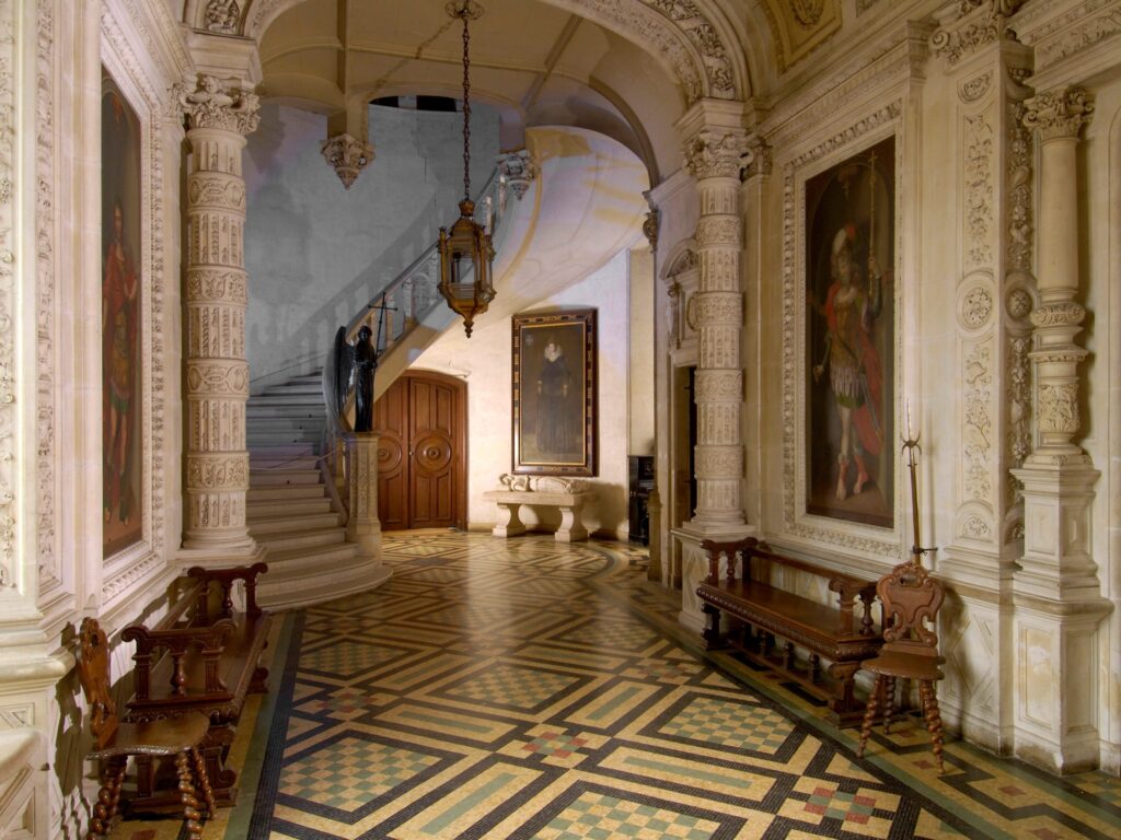 Entrada al Château du Lude Valle del Loir. Suelo de baldosas, paredes altas, pilares de mármol que conducen a la puerta trasera