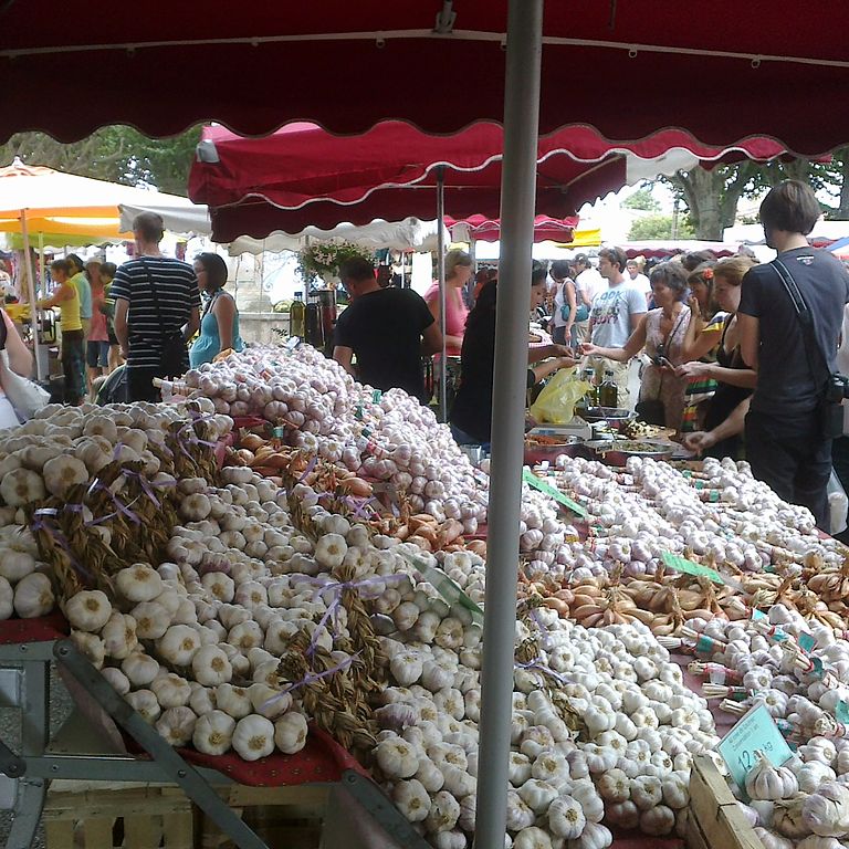 Mercado de Aups con un gran número de racimos de ajo en puestos