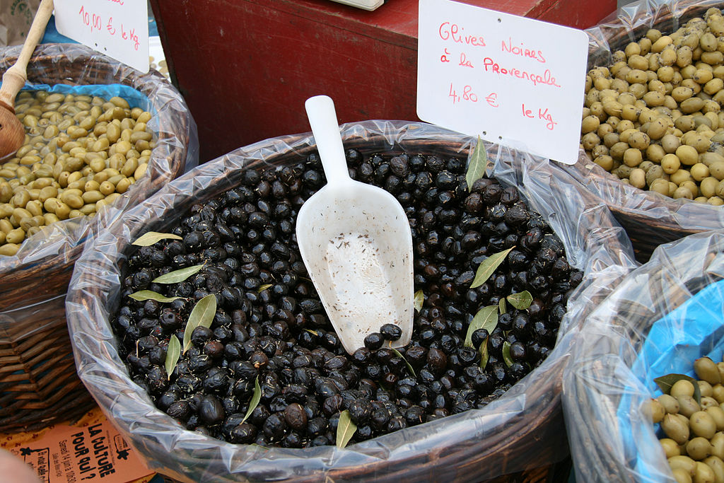 apt market Provence una bolsa de aceitunas negras con una pequeña hélice plateada y hojas verdes