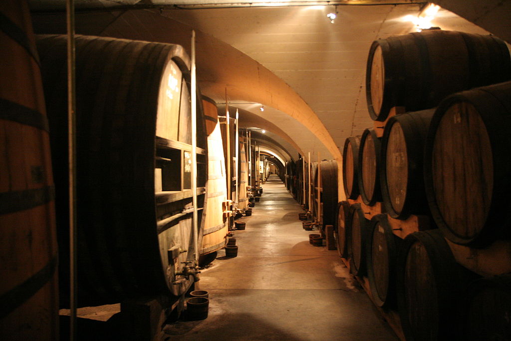 Bodegas Chartreuse con enormes barricas de roble antiguas que recorren ambos lados de la cueva abovedada