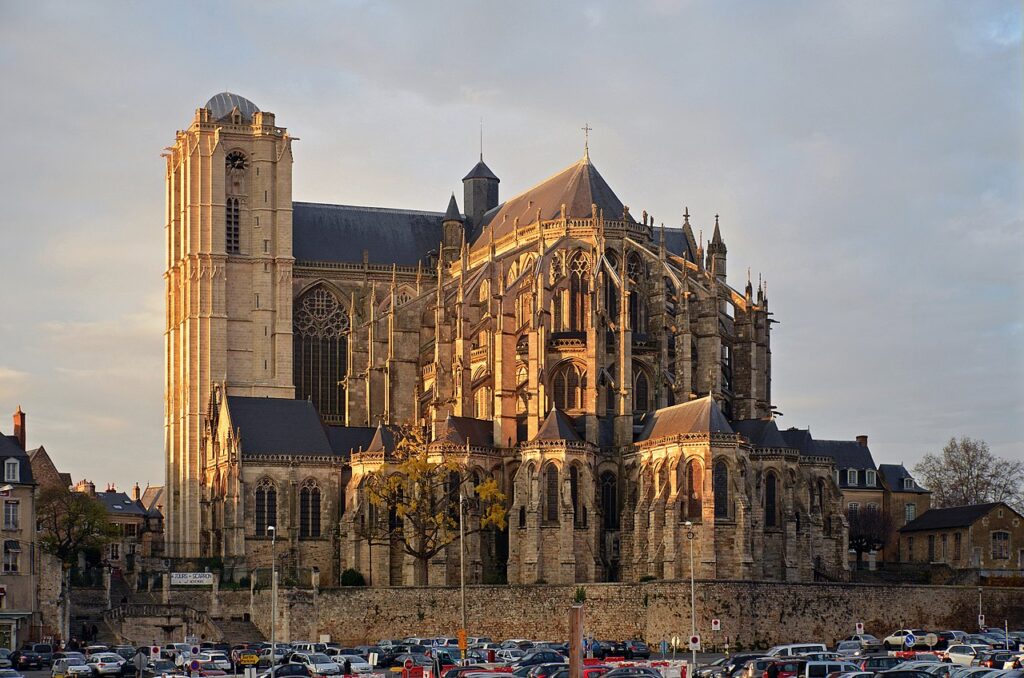 Catedral de St. Julien Le Mans desde el exterior con luz naranja. Volver a la gran iglesia y los edificios circundantes.