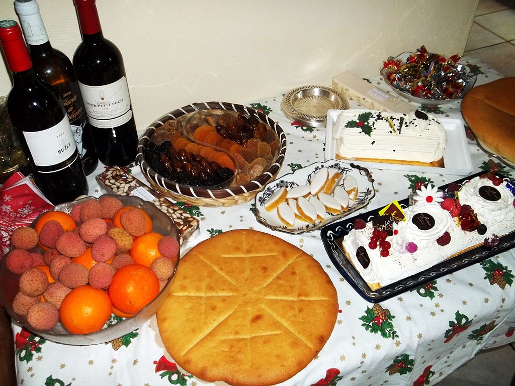 Postres Treize en Provenza: una mesa con botellas de vino al fondo y una mezcla de diferentes postres