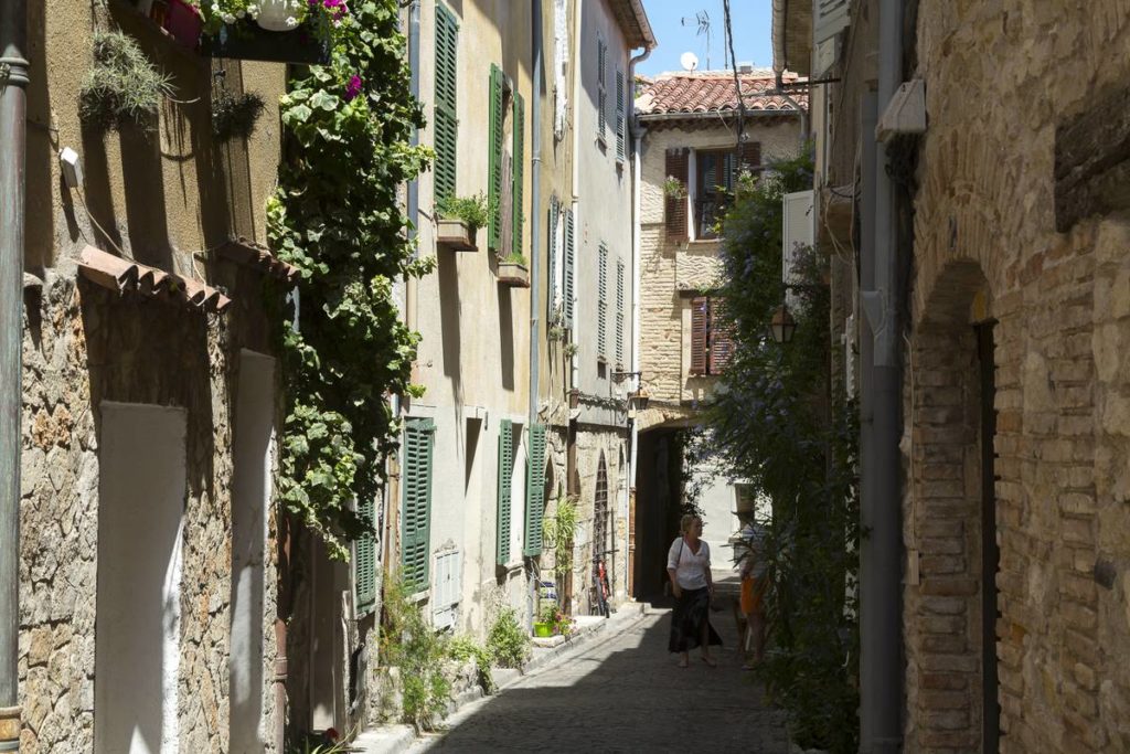 estrechas calles empedradas en antibes con casas de piedra y flores