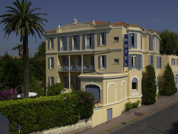 Hotel Alexandra en Juan les Pins Exterior del elegante hotel color arena del siglo XIX con jardín y cobertura en la parte delantera